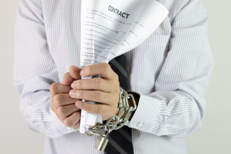 Businessman hands with tied with chains and hold contract