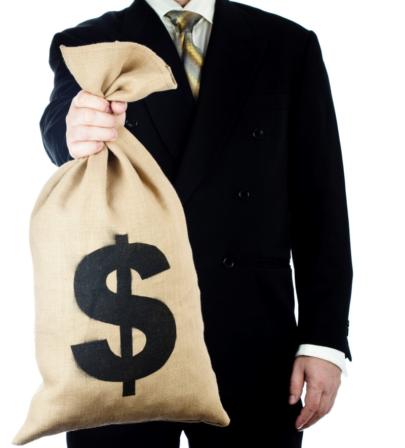 Businessman holding a bag full of money. Isolated on white.