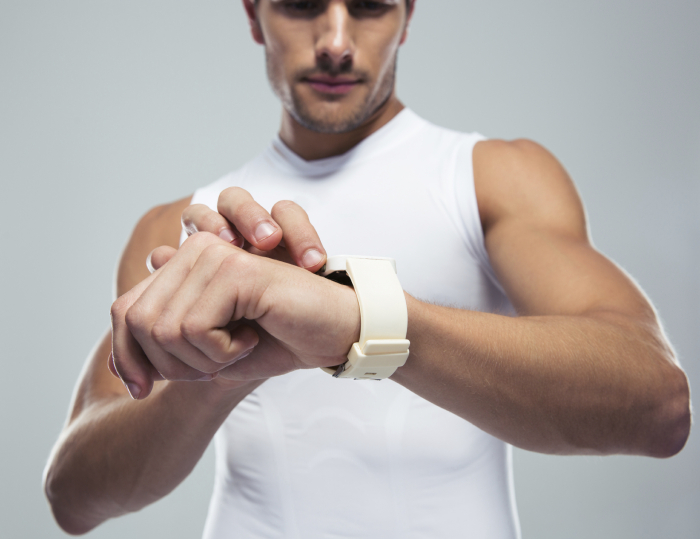 Closeup portrait of a fitness man using smartwatch