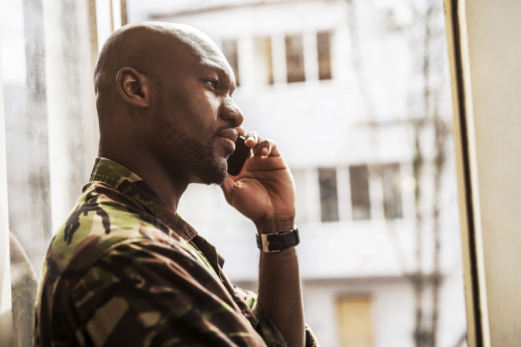 Side view of a young soldier talking on cell phone.