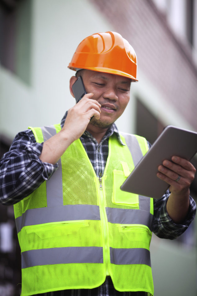 Portrait of construction worker wearing safety vest talking on t
