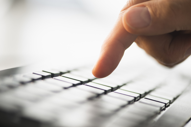 Close-up of finger typing on keyboard