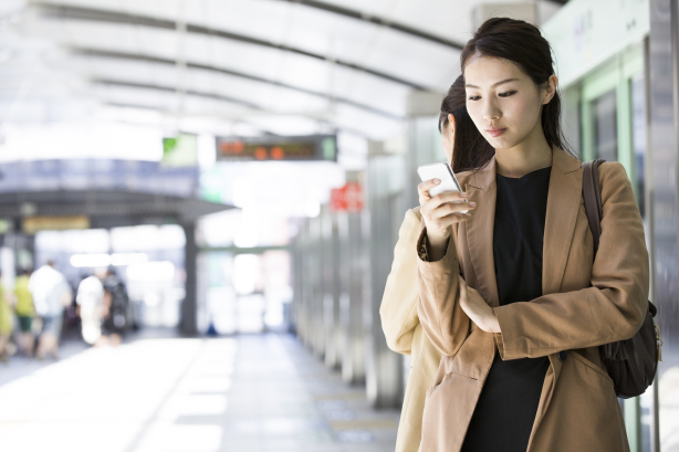 businesswoman checking a smart phone at station