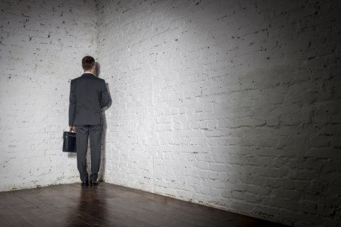 Businessman standing in corner of a room