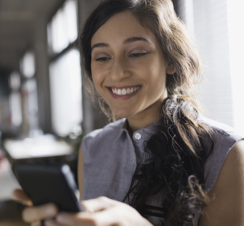 Businesswoman using cell phone in office