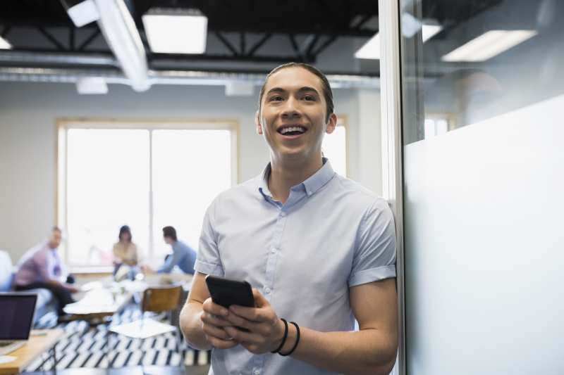 Enthusiastic businessman texting outside meeting