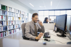 Businessman talking on cell phone at office desk