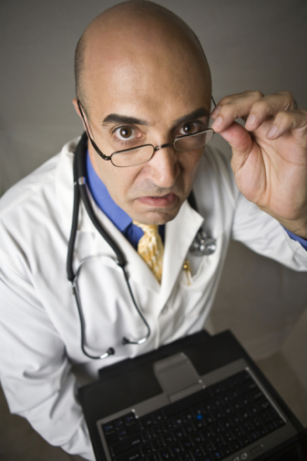 Mad male doctor holding laptop