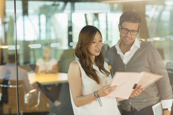 Business people reading paperwork in office