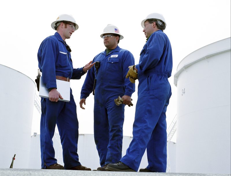 Group of male workers at oil refinery