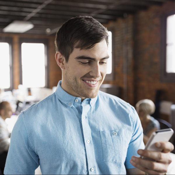 Businessman using cell phone in office