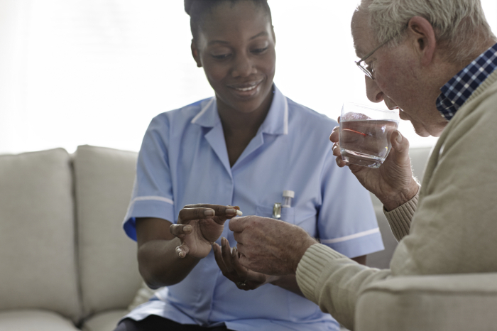 Female Doctor giving medication to elderly patient