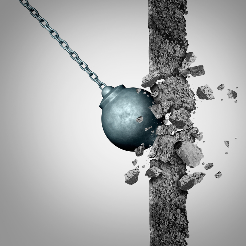Breaking through walls with a heavy wrecking ball destroying a solid cement obstacle as a metaphor for renewal and demolishing limitations as a business symbol with 3D illustration elements.