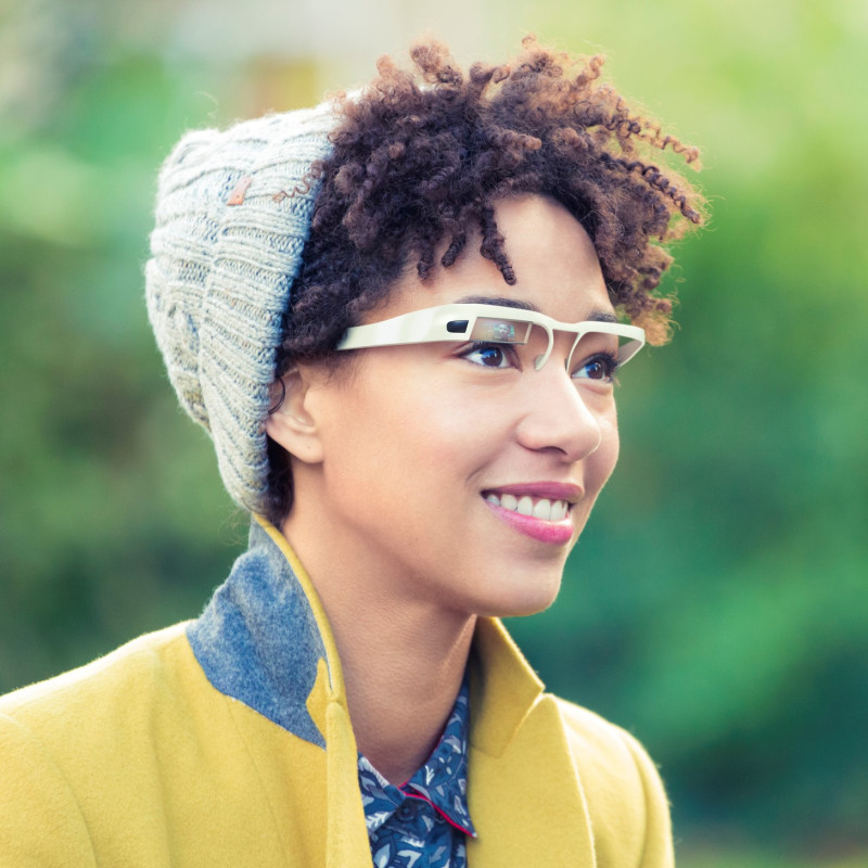 Smiling woman with wearable computer in form of smart glasses. London, UK, autumn.